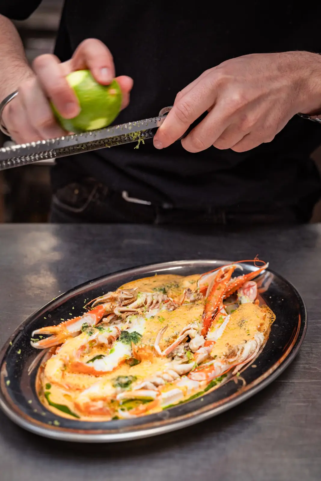 Limoenrasp boven langoustines in een romige saus