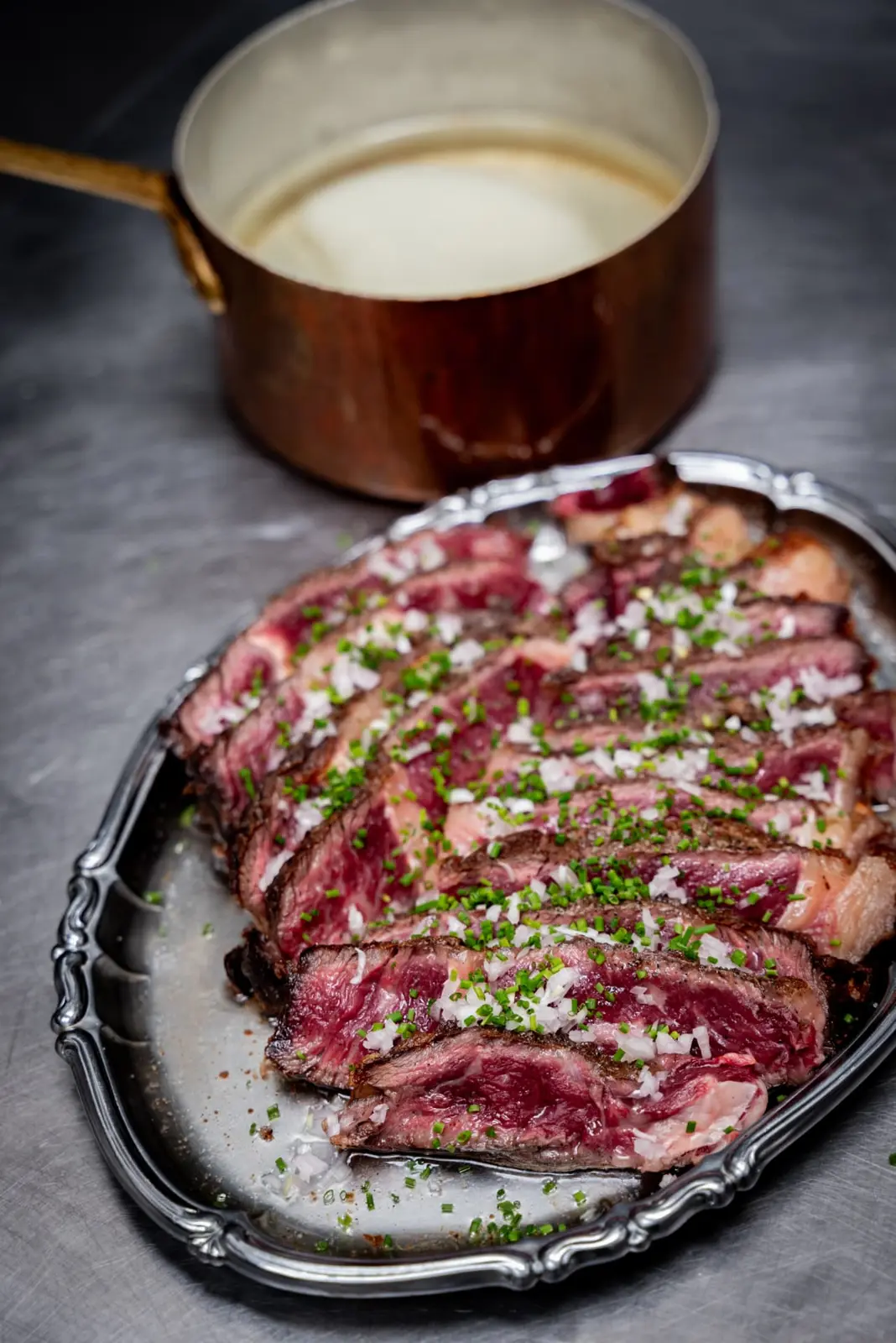 Gesneden côte de boeuf met een koperen pannetje saus