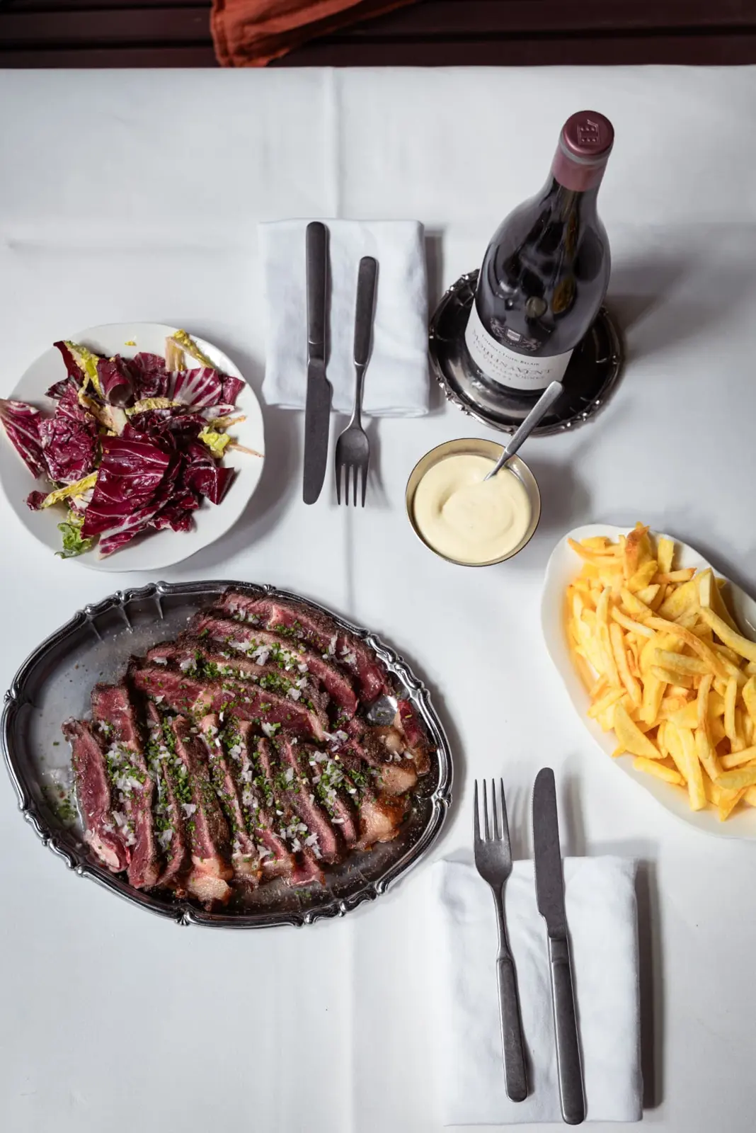 Gedekte tafel met steak-frites op een wit tafellaken